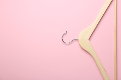 Photo of Wooden hanger on pink background, top view