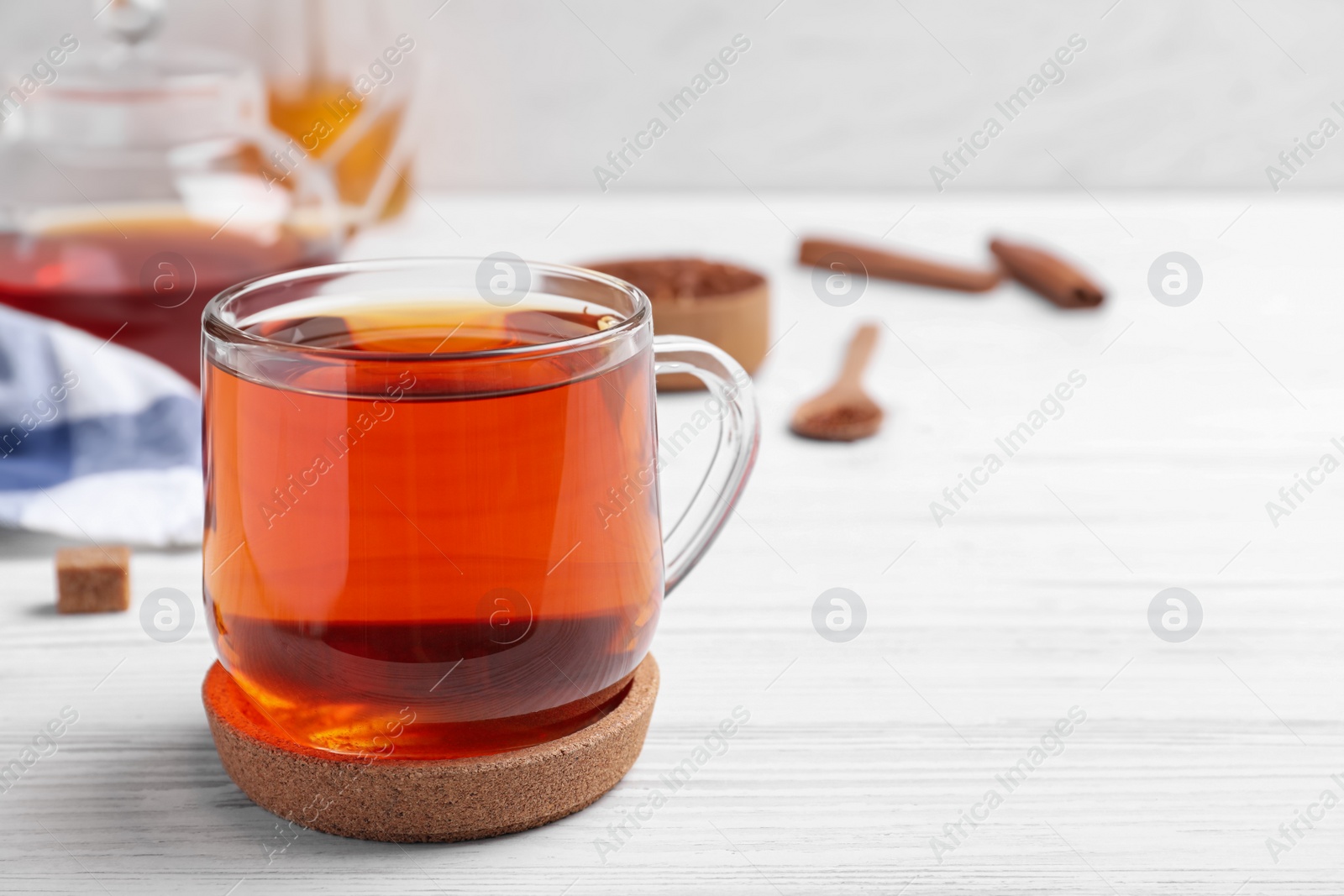 Photo of Freshly brewed rooibos tea on white wooden table. Space for text