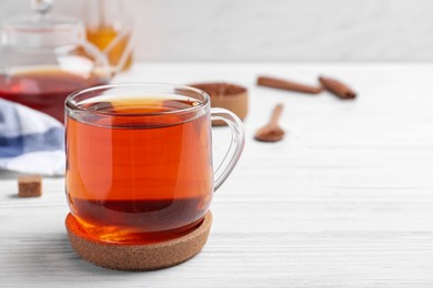 Photo of Freshly brewed rooibos tea on white wooden table. Space for text