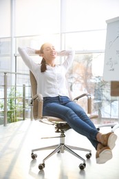 Photo of Young woman relaxing in office chair at workplace