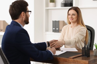 Photo of Lawyer shaking hands with client in office, selective focus