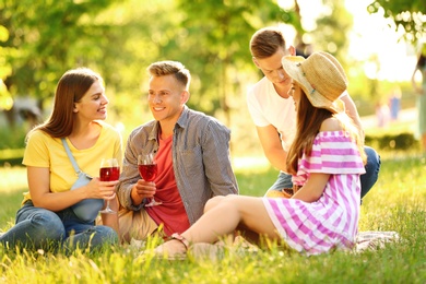 Young people enjoying picnic in park on summer day