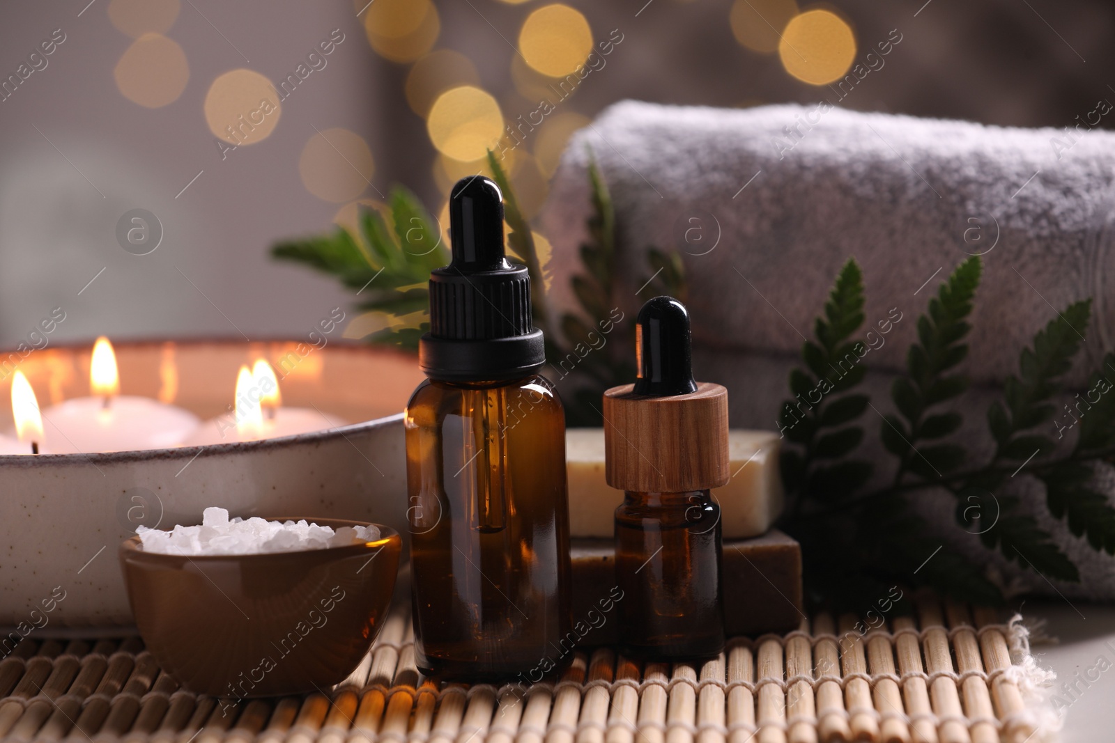 Photo of Beautiful composition with different spa products on table against blurred lights, closeup