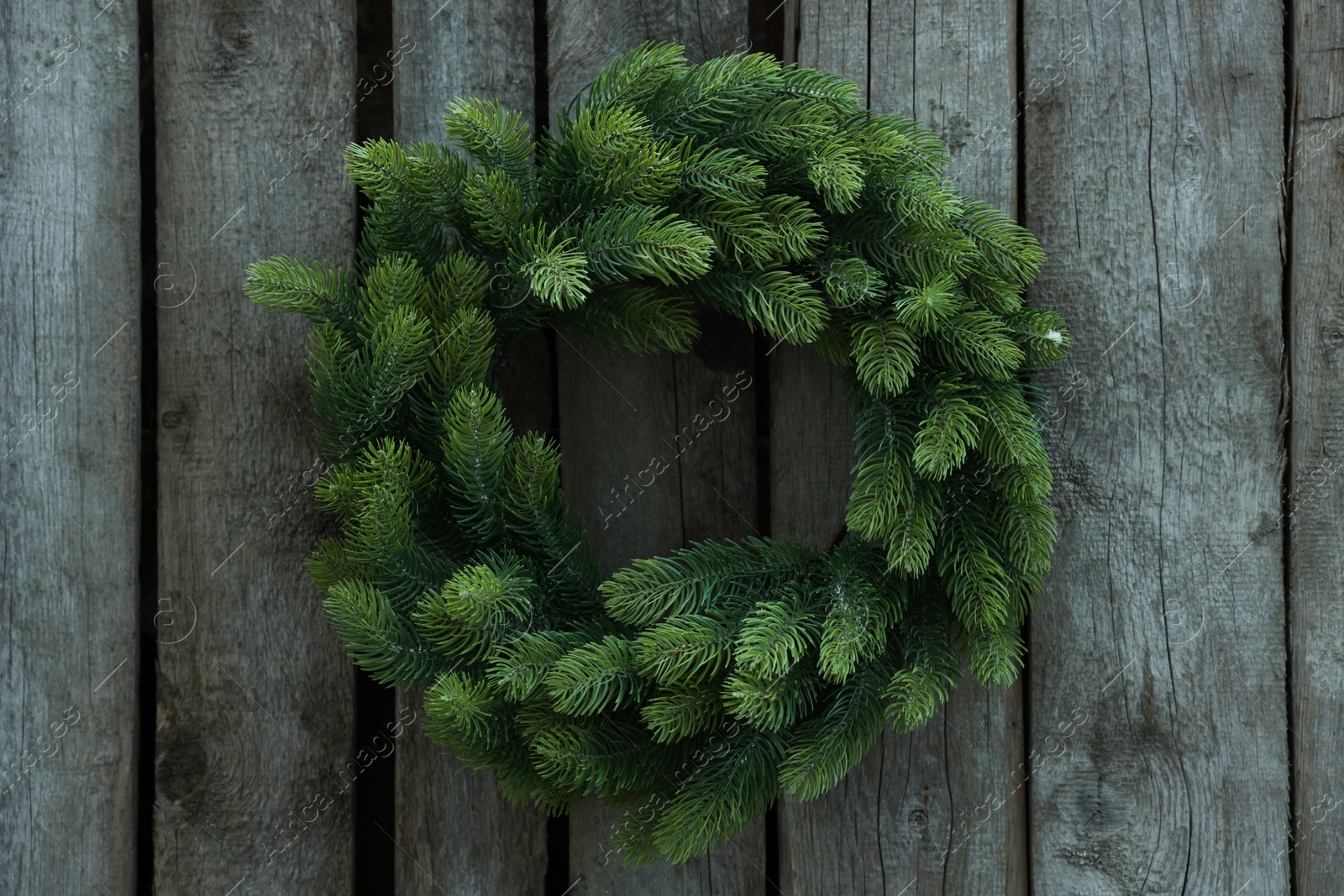 Photo of Beautiful Christmas wreath hanging on wooden wall