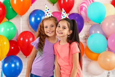 Happy children near bright balloons at birthday party indoors