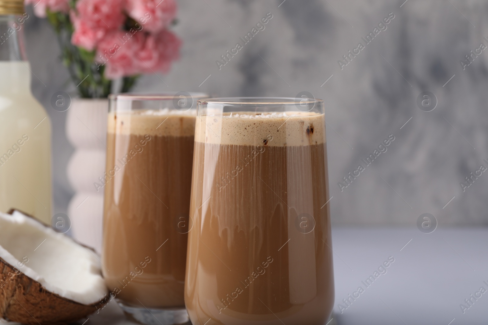 Photo of Delicious coffee with coconut syrup on white table, closeup