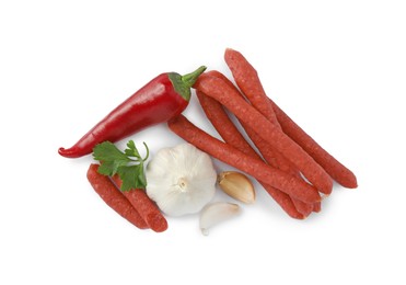 Photo of Thin dry smoked sausages and different spices isolated on white, top view