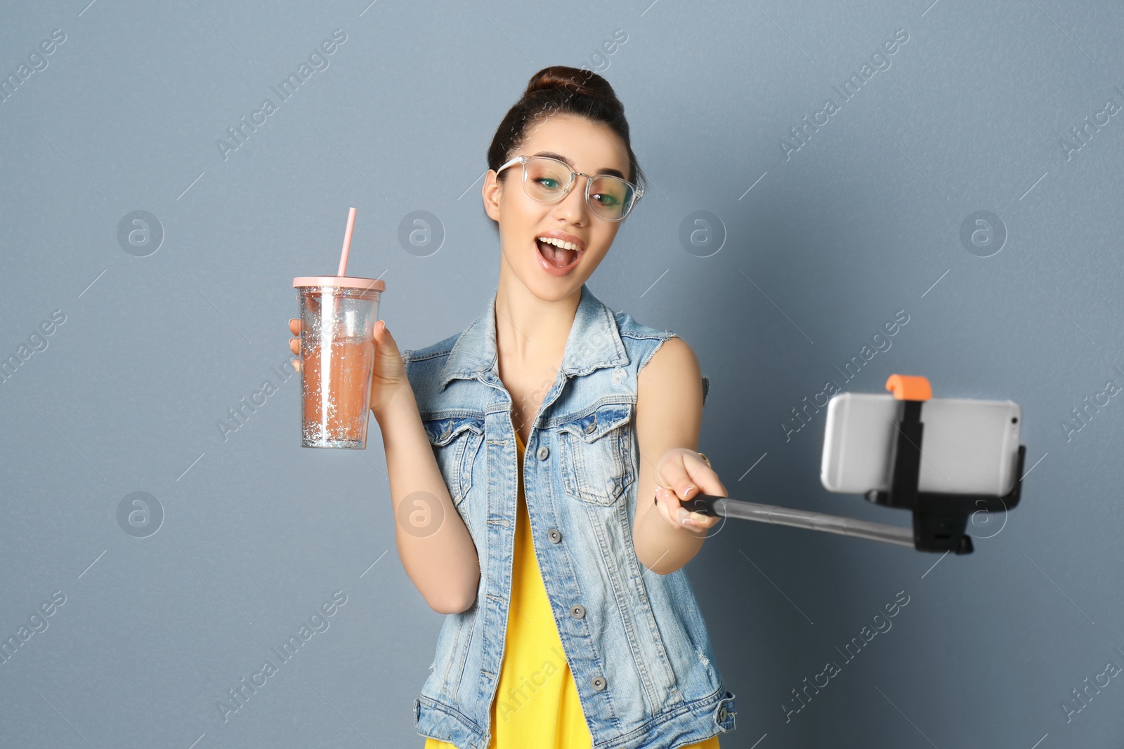 Photo of Young beautiful woman taking selfie against grey background