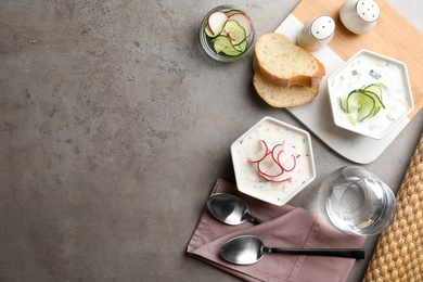 Delicious cold summer soup on grey table, flat lay. Space for text