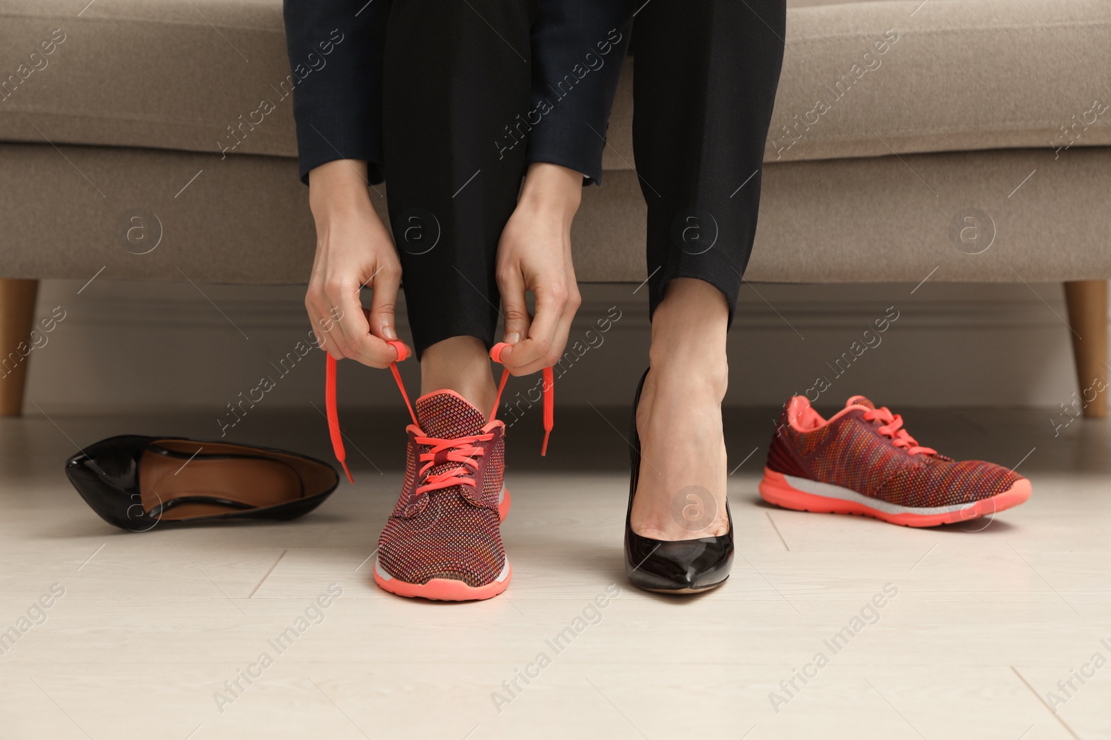 Photo of Woman changing shoes on sofa in office, closeup