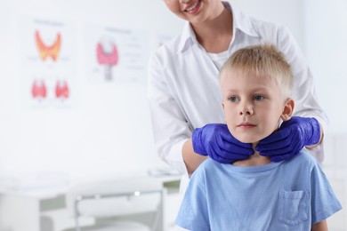 Photo of Endocrinologist examining boy's thyroid gland at hospital, closeup. Space for text