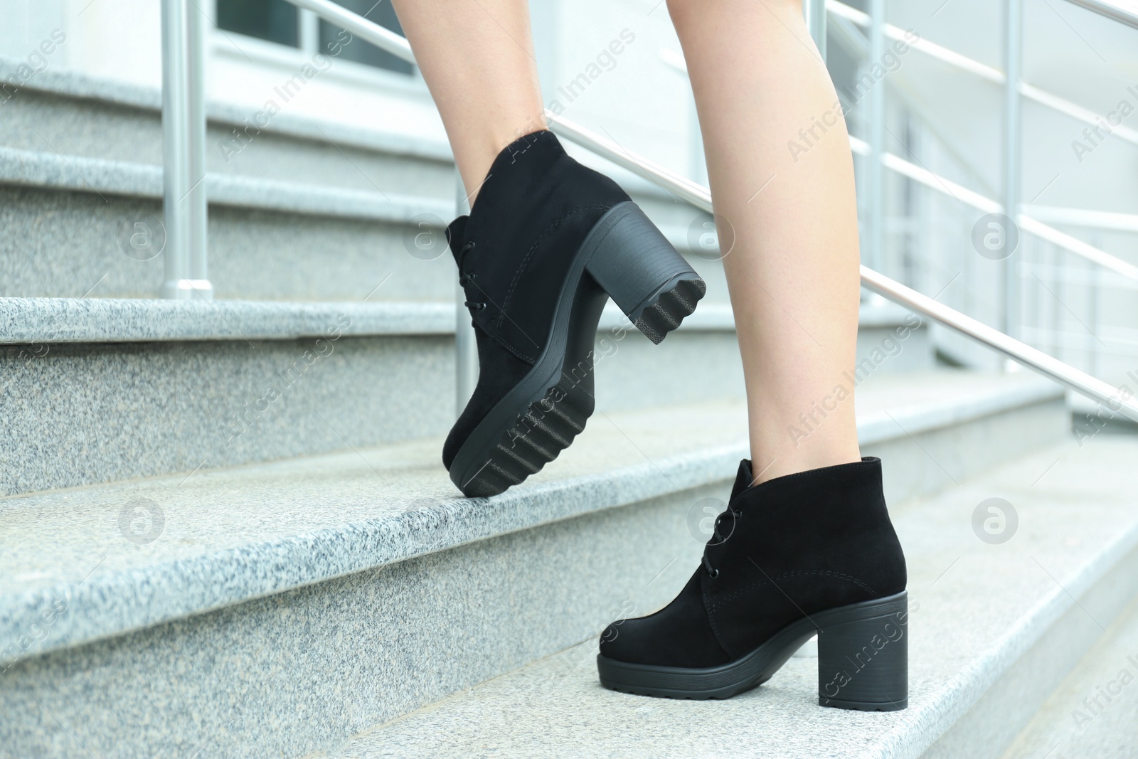 Photo of Woman in stylish boots on stairs outdoors, closeup