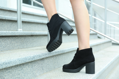 Woman in stylish boots on stairs outdoors, closeup