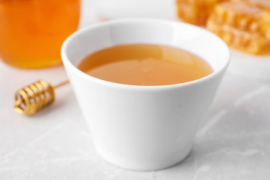 Photo of Tasty honey on light grey marble table