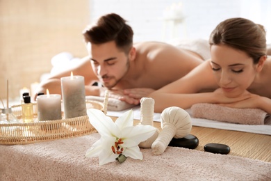 Young couple with spa essentials in wellness center