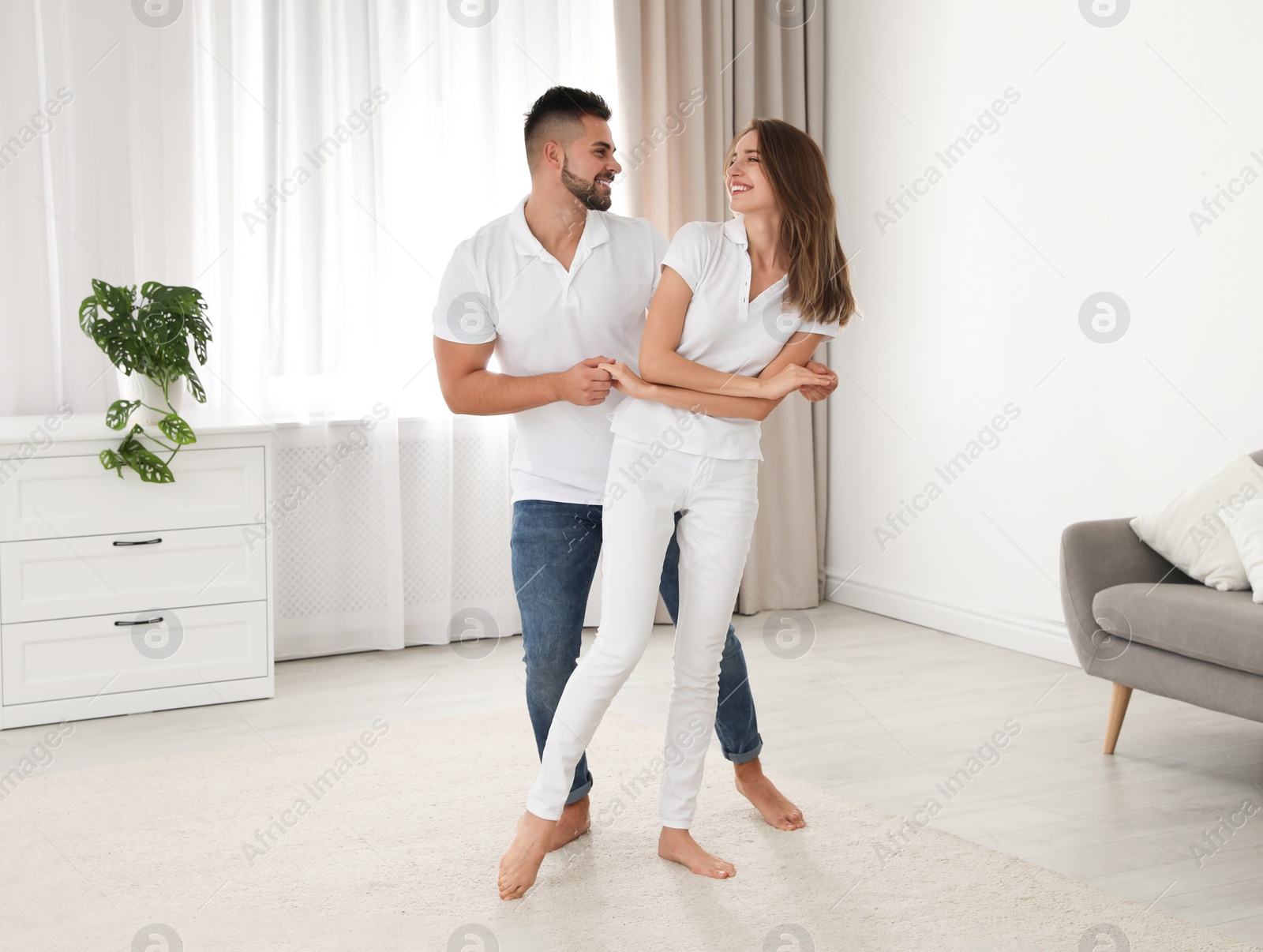 Photo of Lovely young couple dancing together at home