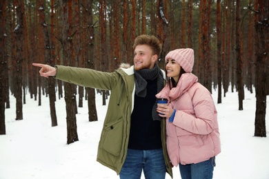 Beautiful young couple in snowy winter forest