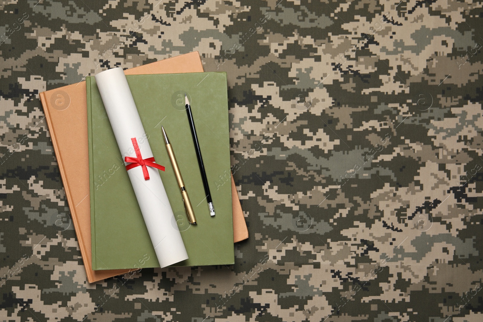 Photo of Notebooks, diploma, pen and pencil on camouflage fabric, top view with space for text. Military education