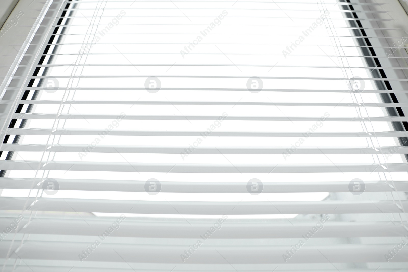 Photo of Stylish horizontal window blinds, low angle view