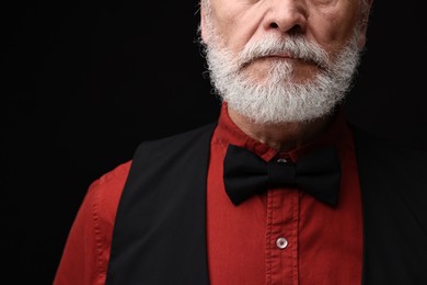 Man with mustache on black background, closeup