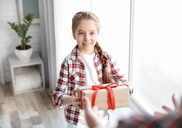 Photo of Little girl giving her dad present for Father's Day at home