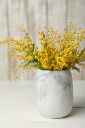 Photo of Bouquet of beautiful mimosa flowers on white wooden table