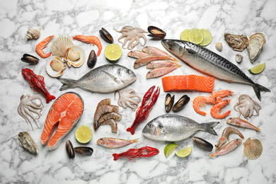 Photo of Fresh fish and different seafood on white marble table, flat lay