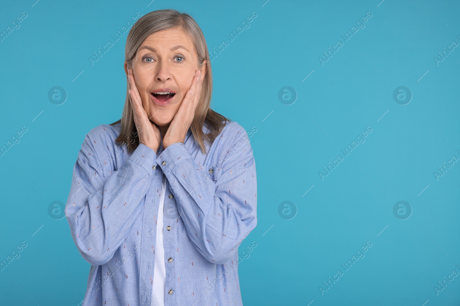 Photo of Portrait of surprised senior woman on light blue background, space for text