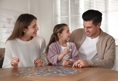 Happy family playing with puzzles at home