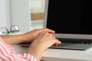 Photo of Young woman working with laptop at workplace, closeup