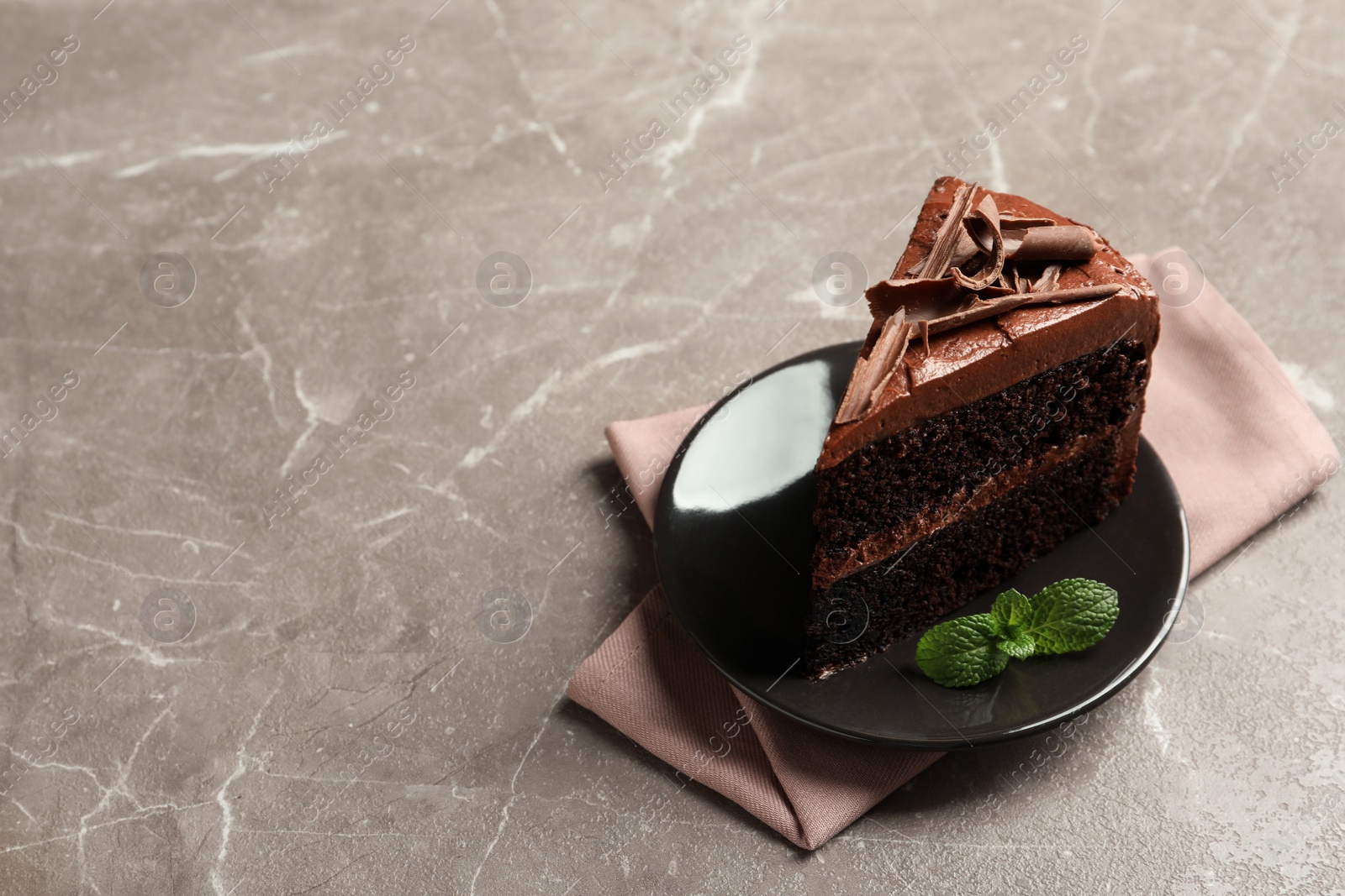 Photo of Plate with slice of tasty homemade chocolate cake on grey table. Space for text