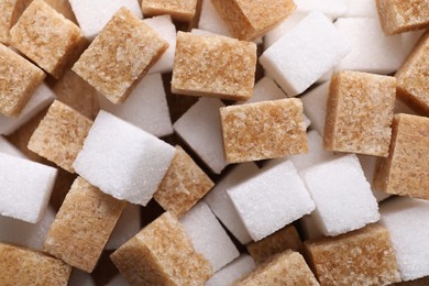 Photo of Brown and white sugar cubes as background, top view