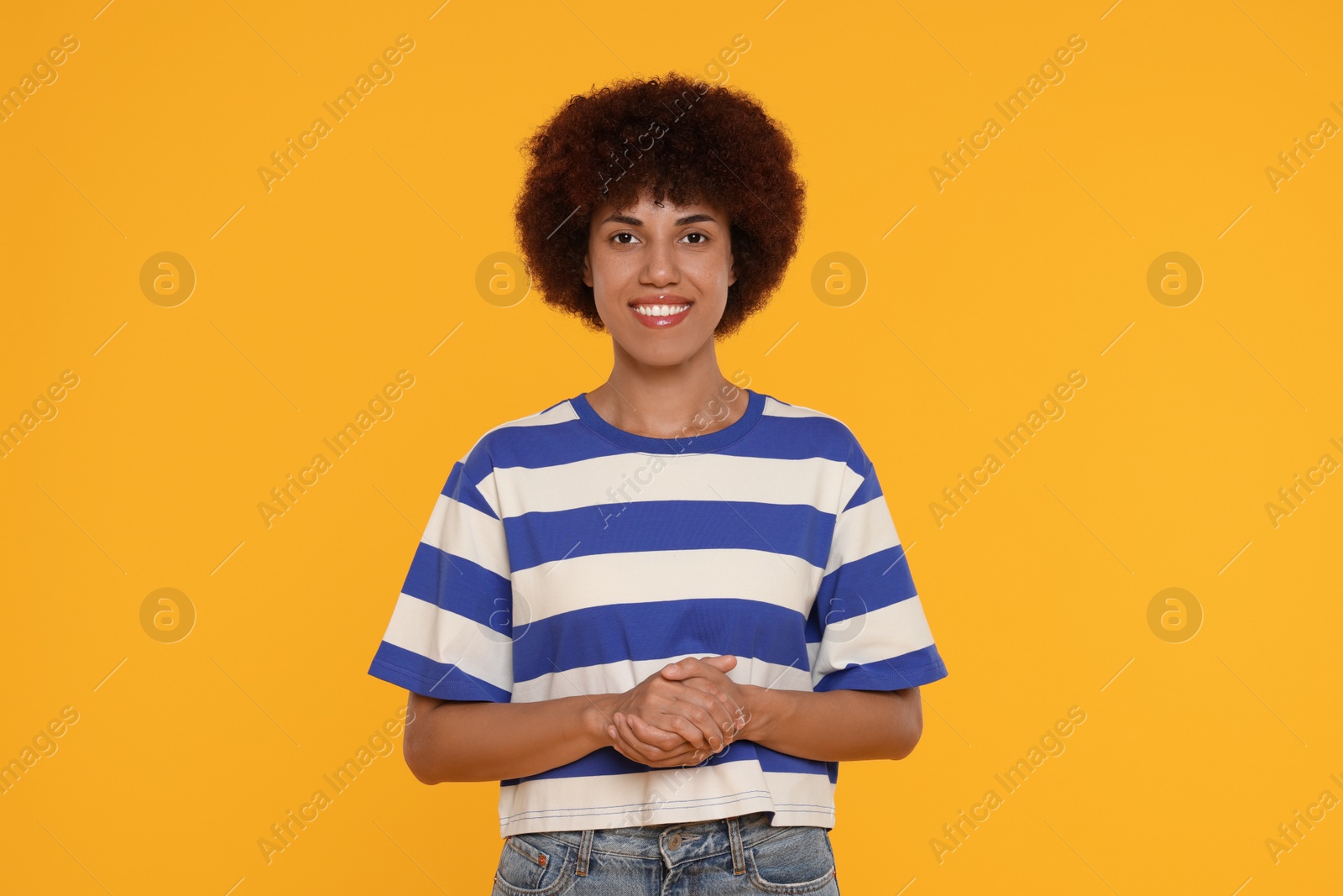 Photo of Portrait of happy young woman on orange background