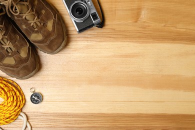 Set of traveler's equipment on wooden table, flat lay. Space for text