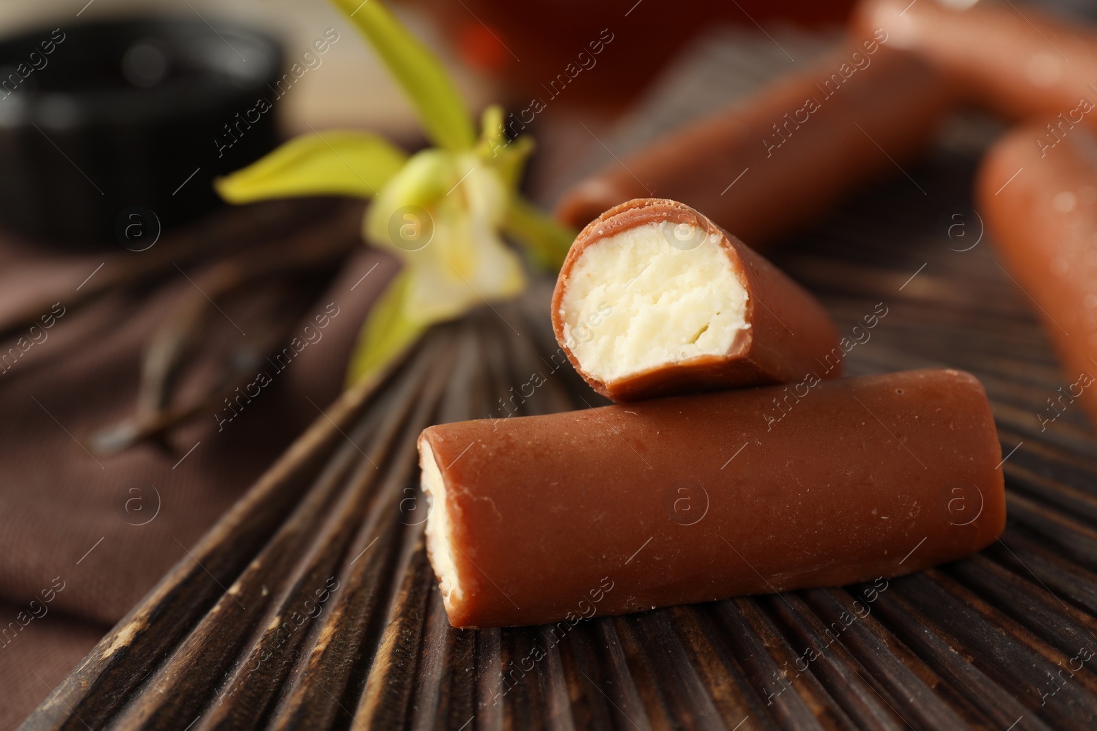 Photo of Glazed curd cheese bars on wooden board, closeup