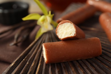 Photo of Glazed curd cheese bars on wooden board, closeup