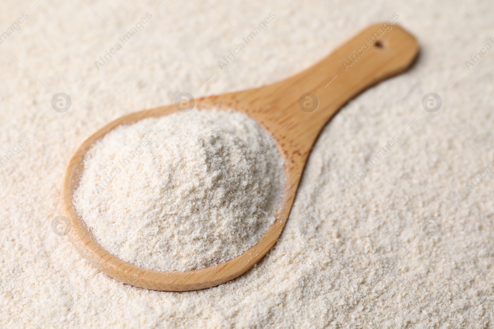 Photo of Quinoa flour and wooden spoon, closeup view