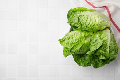 Photo of Fresh green romaine lettuces on white tiled table, flat lay. Space for text