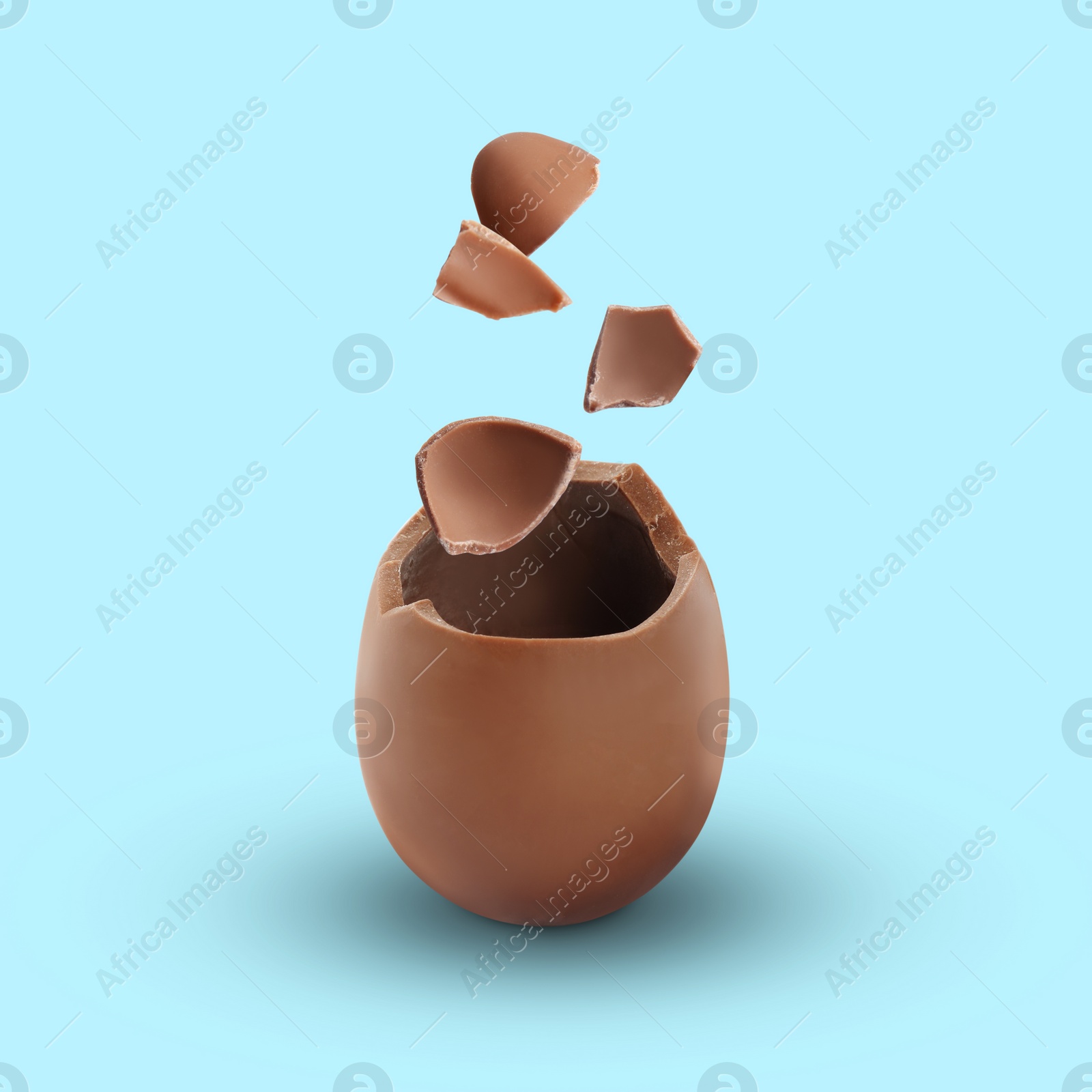 Image of Exploded milk chocolate egg on light blue background