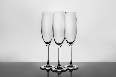 Photo of Empty clear champagne glasses on white background
