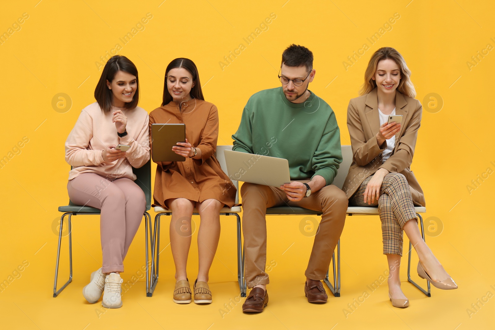 Photo of People waiting for job interview on yellow background