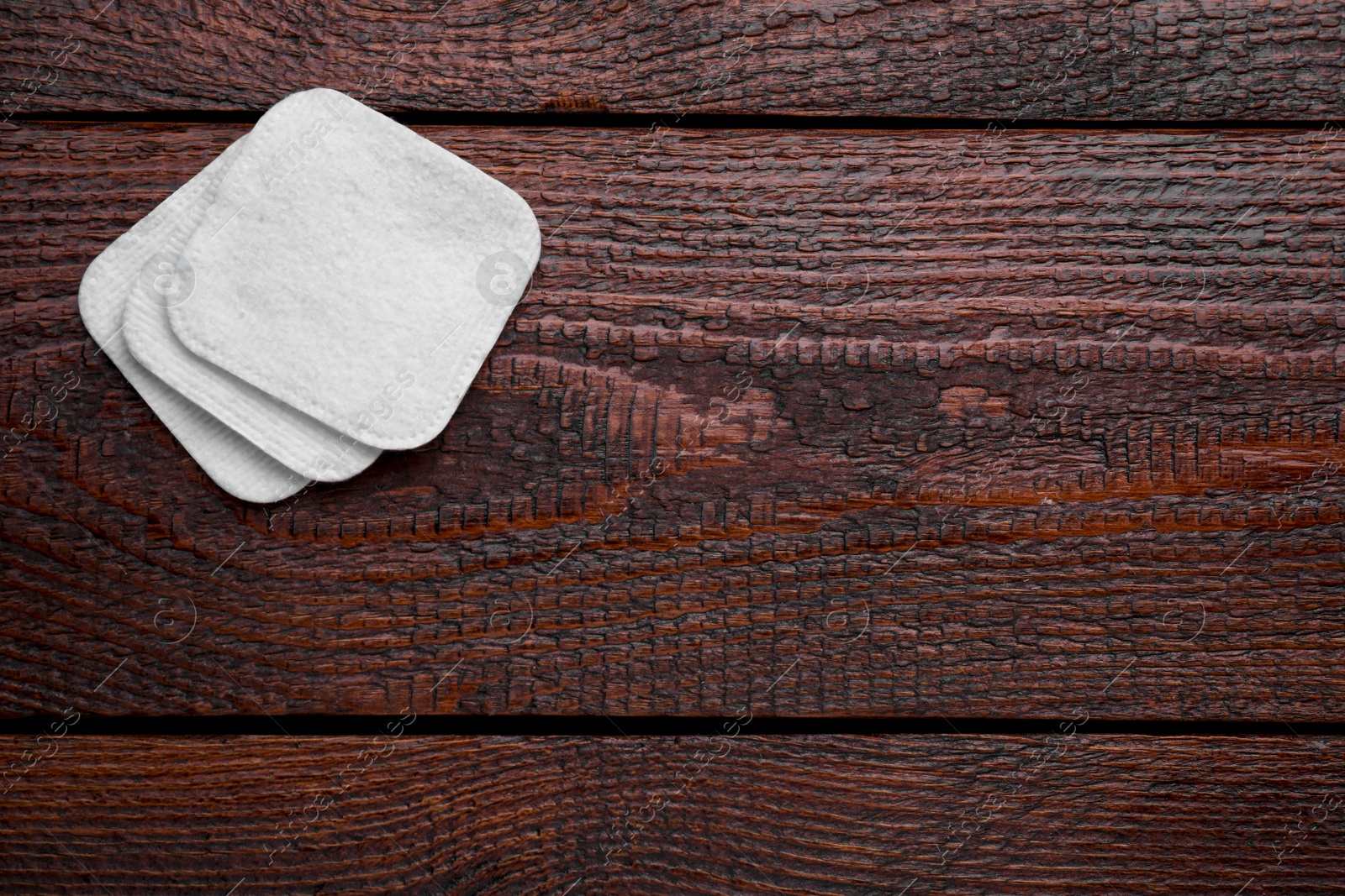 Photo of Clean cotton pads on wooden table, flat lay. Space for text