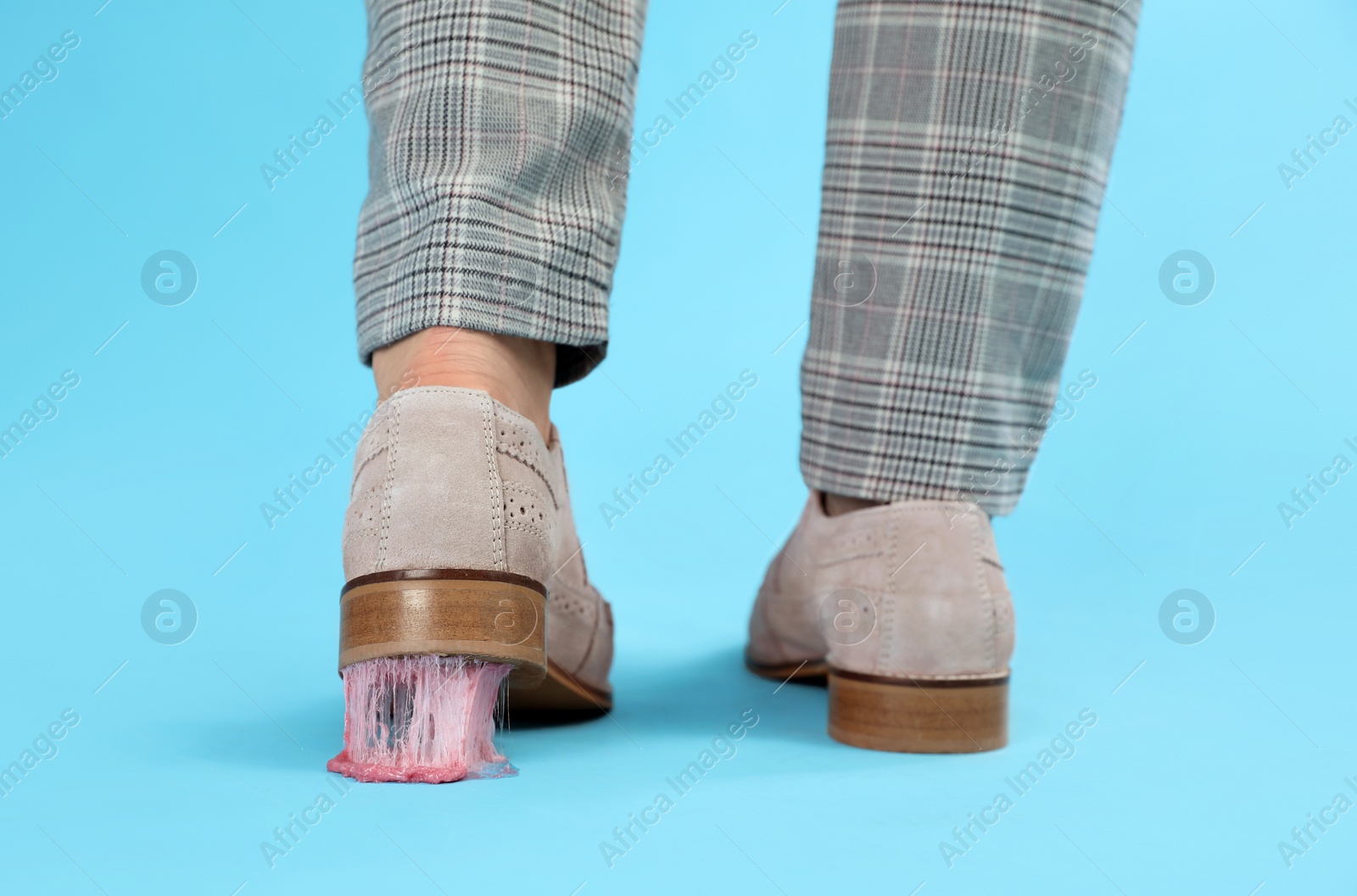 Photo of Person stepping into chewing gum on light blue background, closeup