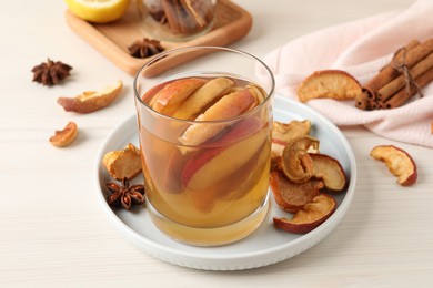 Photo of Delicious compot with dried apple slices on light wooden table