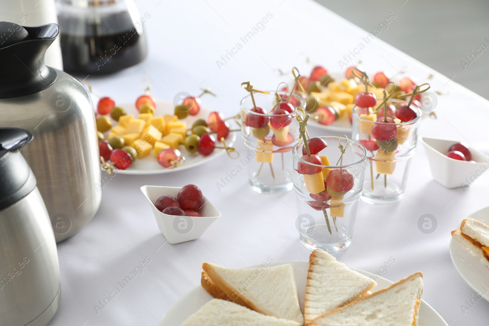 Photo of Table with different delicious snacks indoors. Coffee break