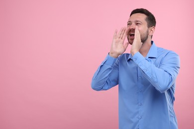 Photo of Special promotion. Man shouting to announce information on pink background. Space for text
