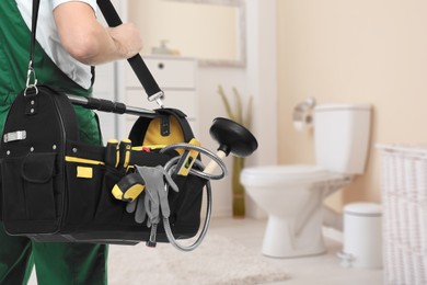 Image of Plumber with bag of instruments in bathroom, closeup. Space for text