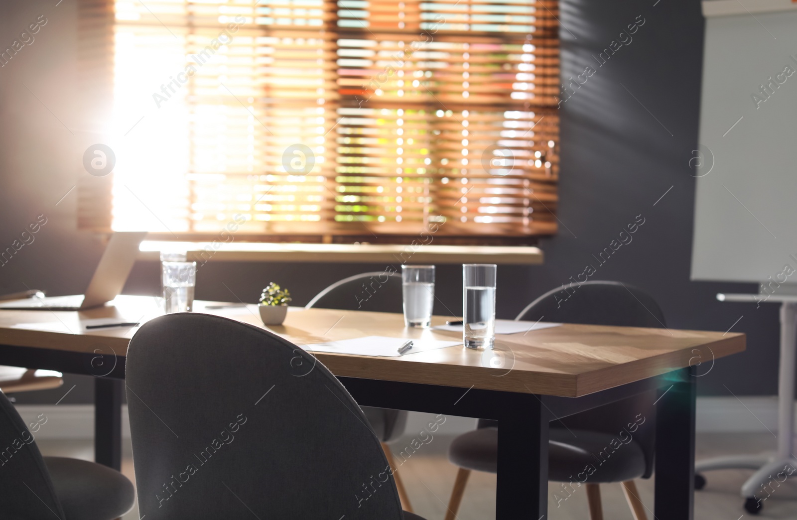 Photo of Stylish office interior with wooden table in morning