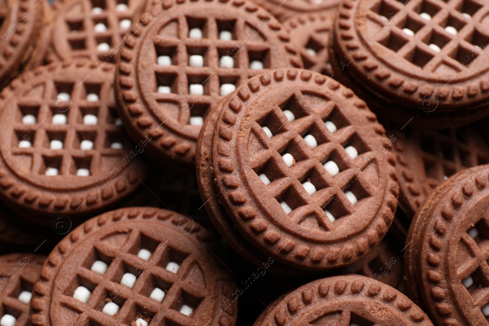 Photo of Tasty chocolate sandwich cookies with cream as background, closeup