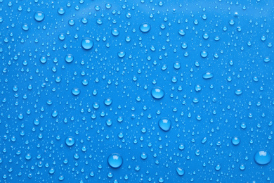 Photo of Water drops on blue background, top view